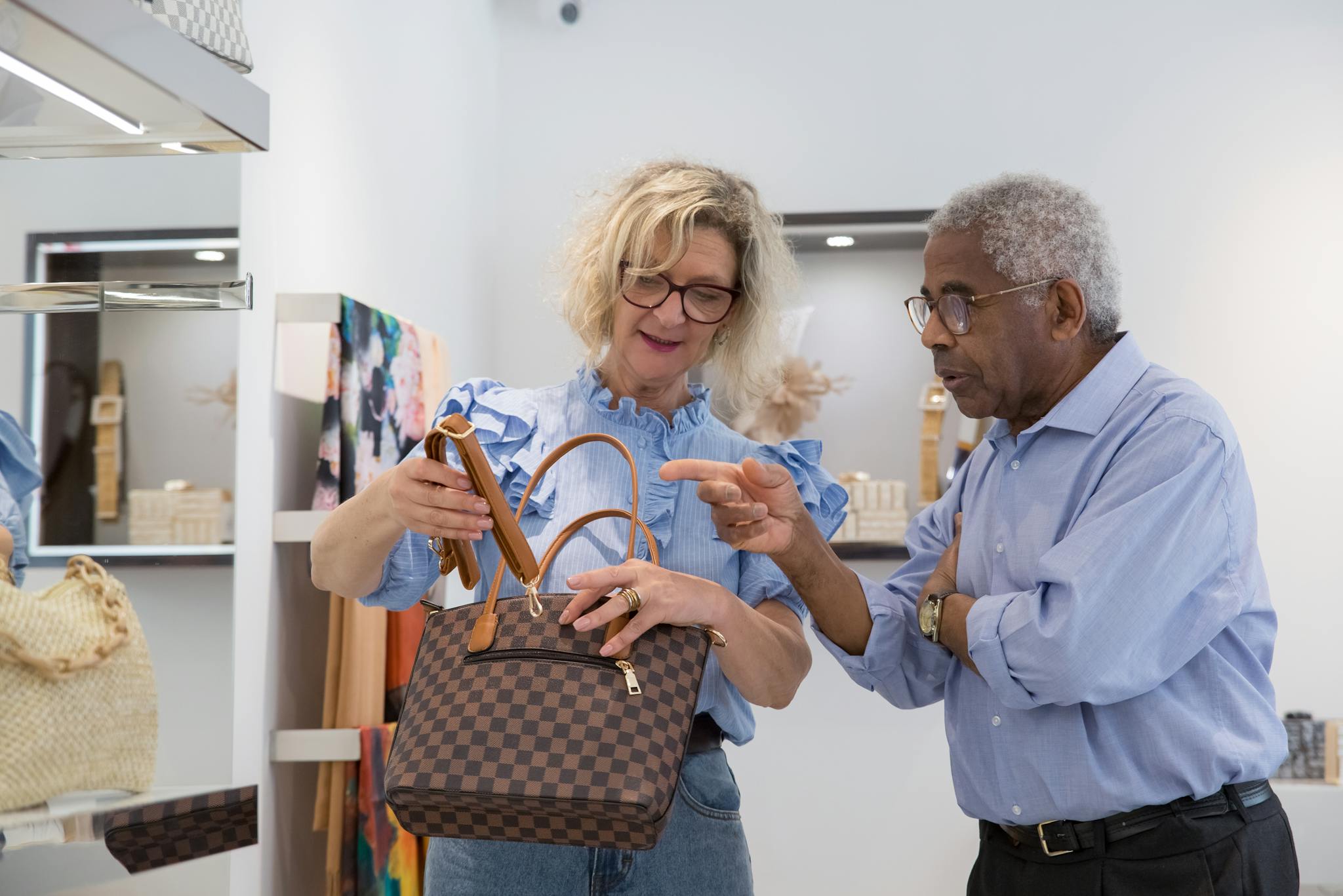 Senior couple browsing handbags in a stylish retail store in Portugal.